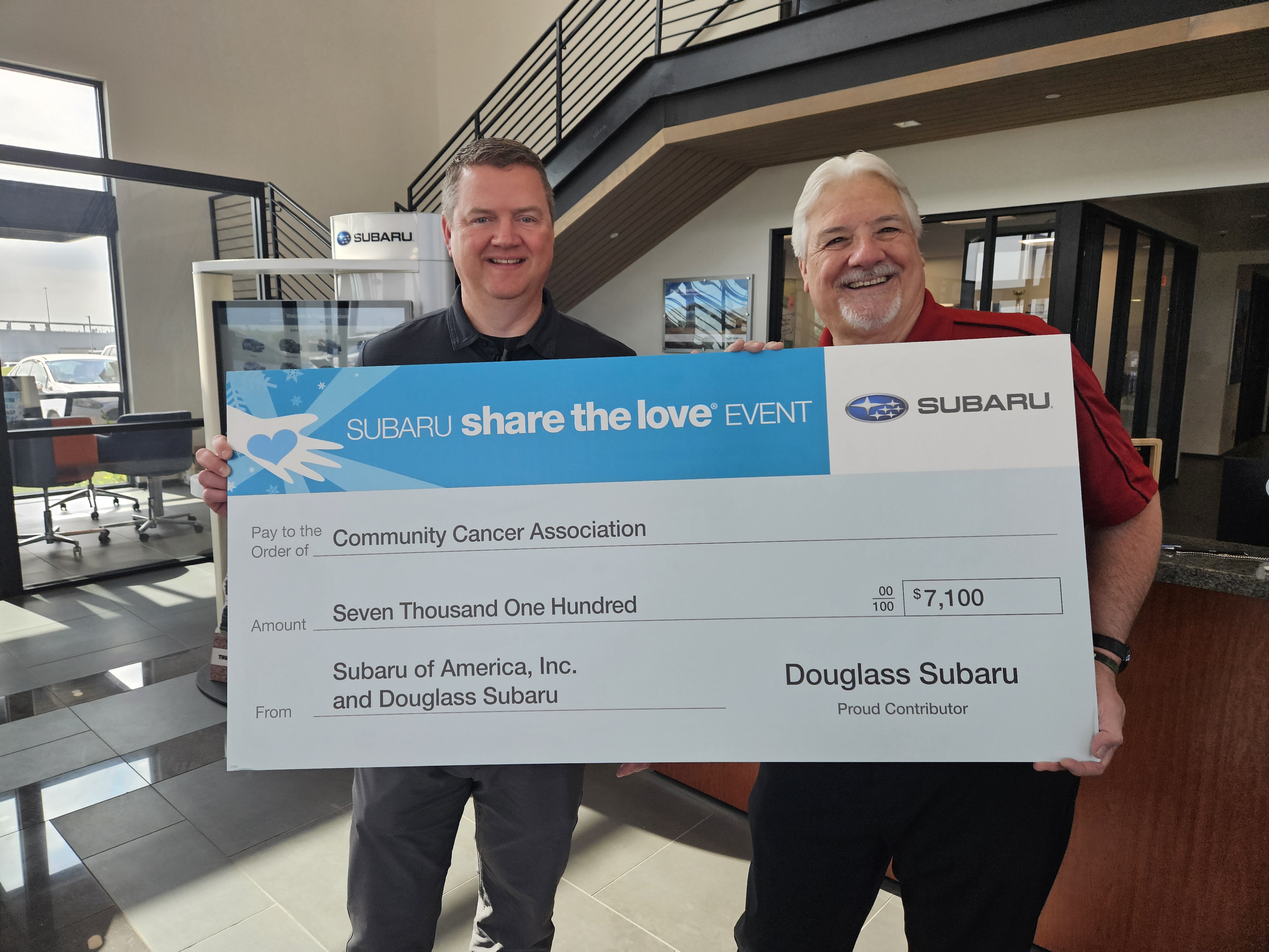 Douglass Subaru and CCA representatives holding a Share the Love donation check